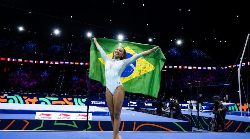 Rebeca Andrade comemora com a bandeira do Brasil no Mundial de Ginástica Artística de 2026, em Roterdã.